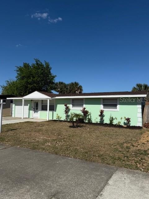 single story home featuring an attached garage and a front lawn