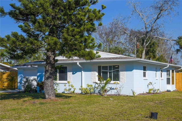 ranch-style home featuring a front lawn and fence