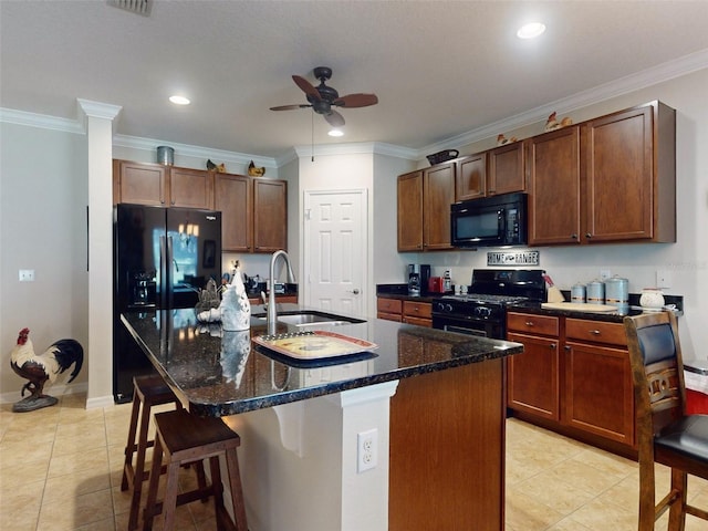 kitchen with light tile patterned floors, ceiling fan, a sink, black appliances, and a kitchen breakfast bar