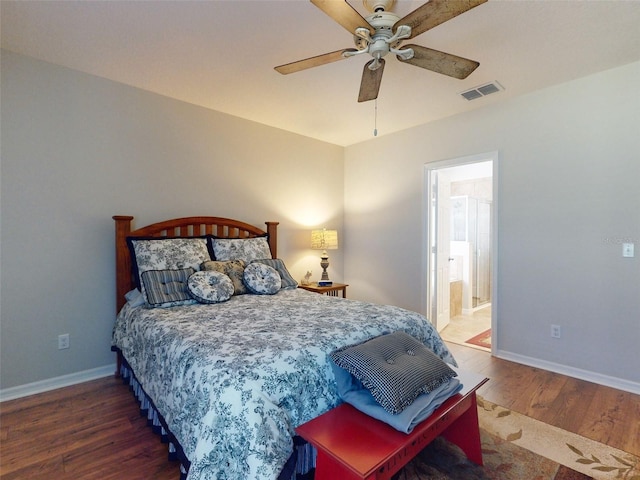 bedroom featuring a ceiling fan, wood finished floors, visible vents, baseboards, and connected bathroom