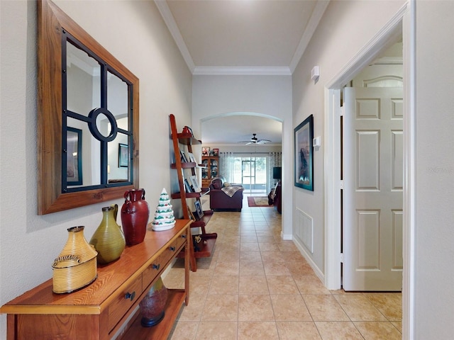 hallway featuring light tile patterned floors, visible vents, and ornamental molding