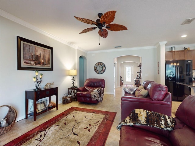 living area with visible vents, crown molding, ceiling fan, light tile patterned floors, and arched walkways