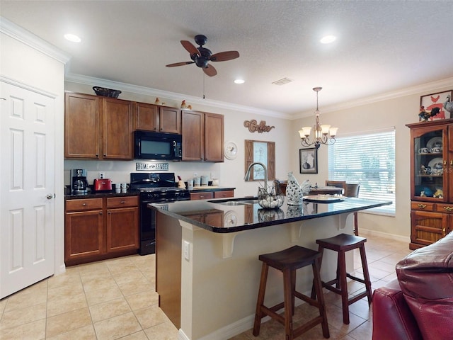 kitchen featuring a sink, dark countertops, black appliances, and a breakfast bar