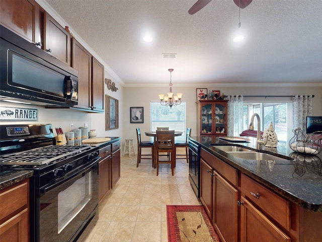 kitchen with light tile patterned floors, plenty of natural light, black appliances, and a sink