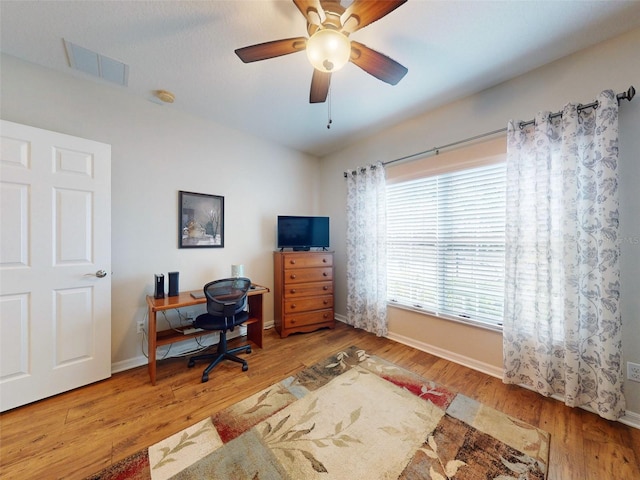 office area featuring a ceiling fan, wood finished floors, visible vents, and baseboards