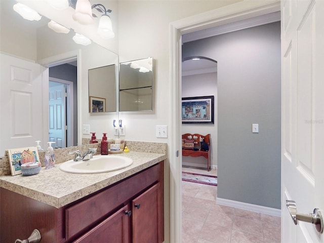 bathroom with baseboards, ornamental molding, vanity, and tile patterned flooring