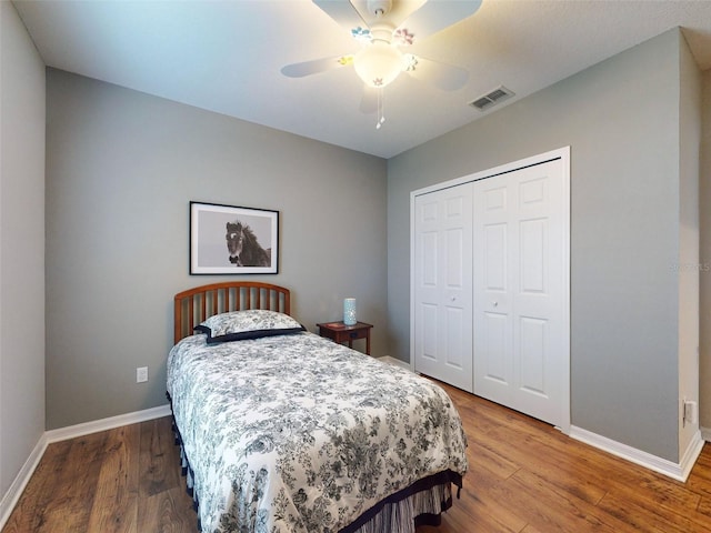 bedroom with visible vents, baseboards, a closet, and wood finished floors