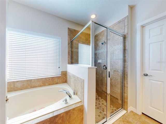 bathroom featuring a garden tub, a stall shower, and tile patterned flooring