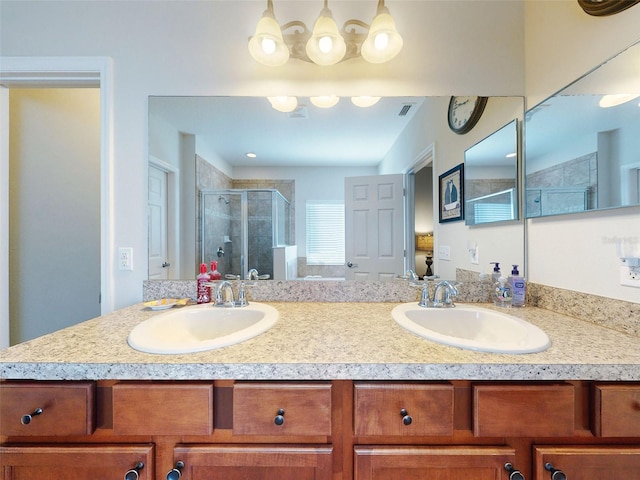 full bath with double vanity, a shower stall, and a sink