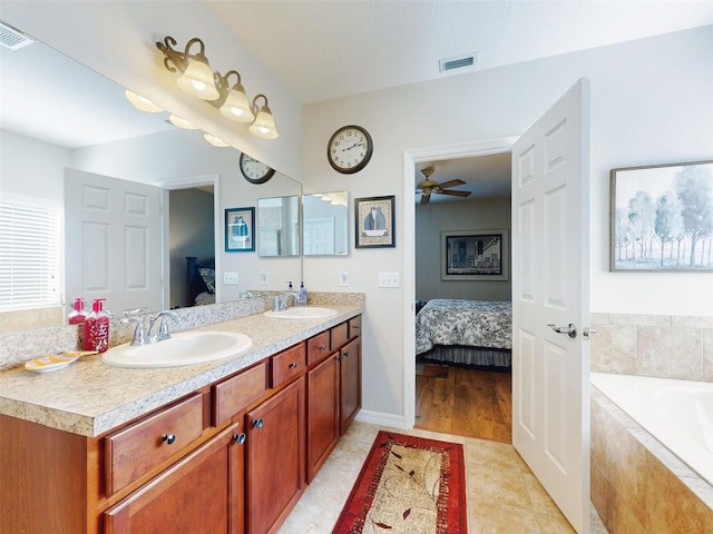 ensuite bathroom with visible vents, double vanity, a sink, a bath, and connected bathroom