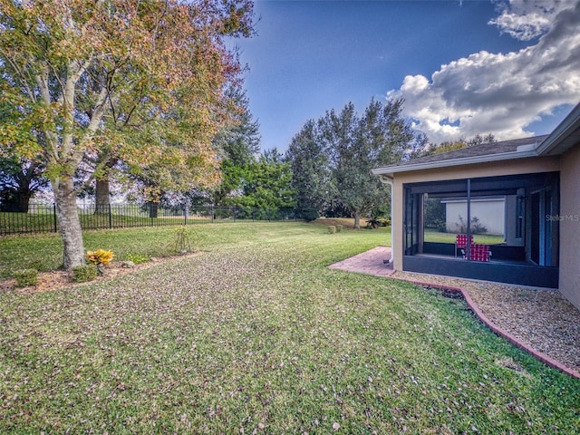 view of yard with fence and a sunroom