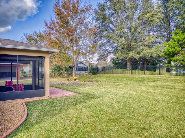 view of yard featuring fence and a sunroom