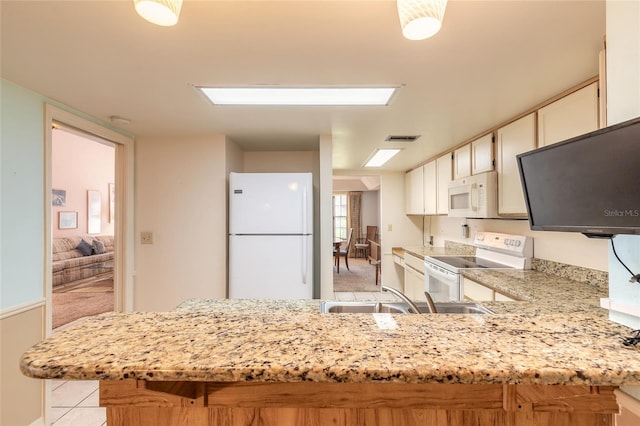 kitchen featuring visible vents, light stone counters, white appliances, a peninsula, and light tile patterned flooring