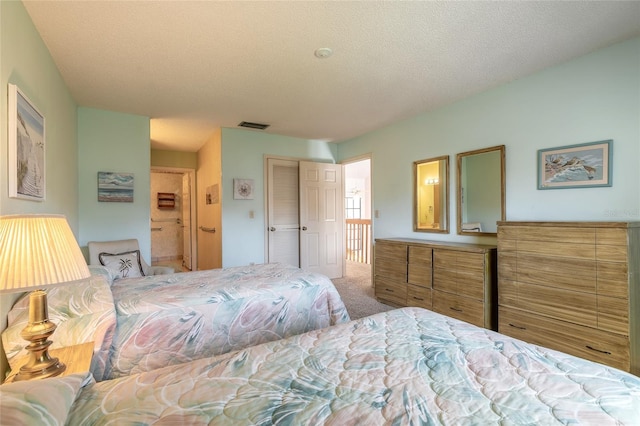 bedroom featuring carpet flooring, a textured ceiling, and visible vents