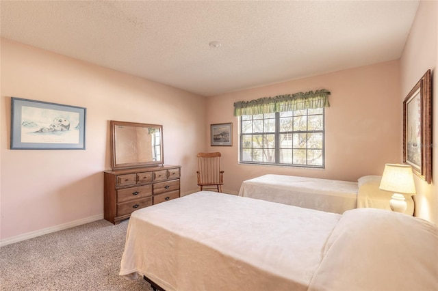 bedroom featuring a textured ceiling, baseboards, and carpet