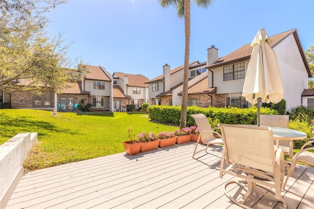 deck featuring a yard, a residential view, and outdoor dining area