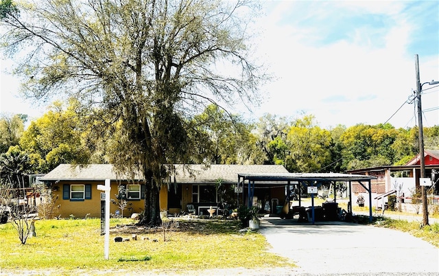 view of front of home with an attached carport, driveway, and a front lawn