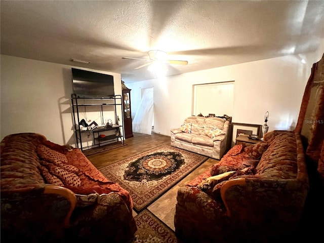 living room with a textured ceiling and ceiling fan