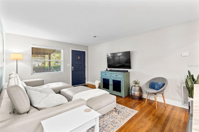 living room featuring visible vents, baseboards, and wood finished floors