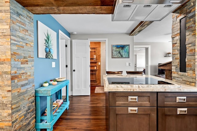 kitchen with dark wood-type flooring, light stone counters, black electric cooktop, and a peninsula