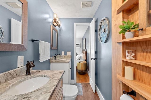 bathroom featuring visible vents, wood finished floors, and a sink