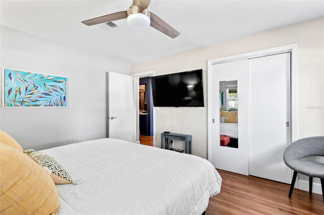 bedroom with visible vents, a closet, wood finished floors, and a ceiling fan