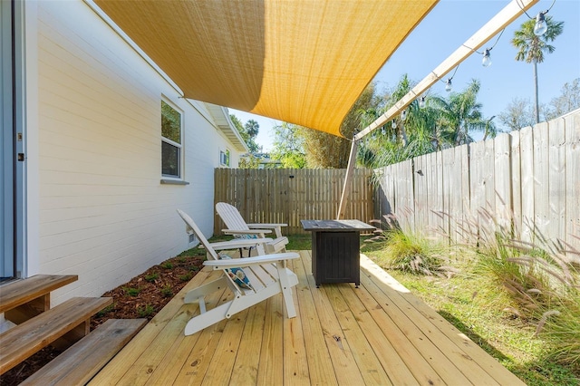 wooden terrace with a fenced backyard