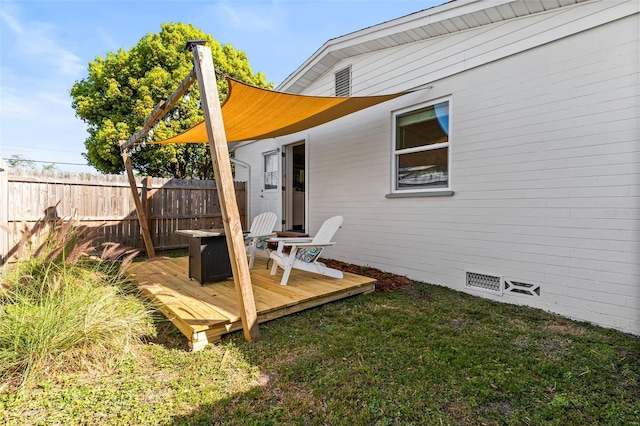 wooden terrace featuring a yard and fence