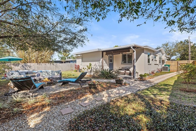 view of front facade featuring a patio area, central AC, and fence