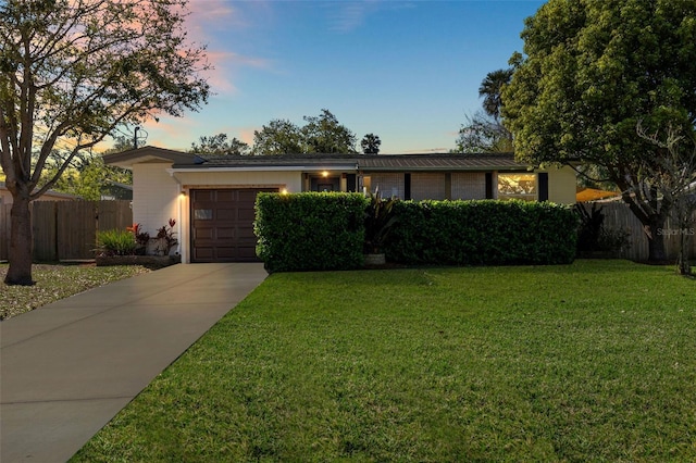 view of front of house with a garage, a front yard, driveway, and fence