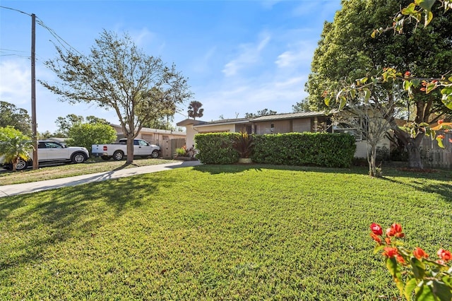 view of yard featuring fence and driveway