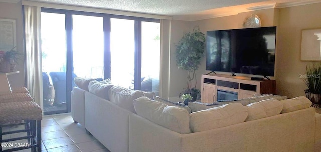 living room featuring light tile patterned floors, plenty of natural light, a textured ceiling, and a glass covered fireplace