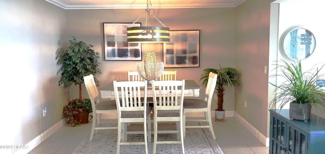 dining space featuring tile patterned floors, a notable chandelier, crown molding, and baseboards