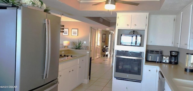 kitchen with ceiling fan, light countertops, appliances with stainless steel finishes, light tile patterned flooring, and white cabinetry