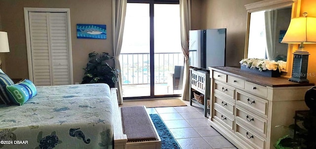 bedroom with access to outside and light tile patterned flooring