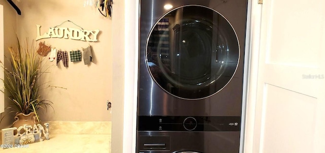 washroom featuring laundry area and stacked washer / dryer