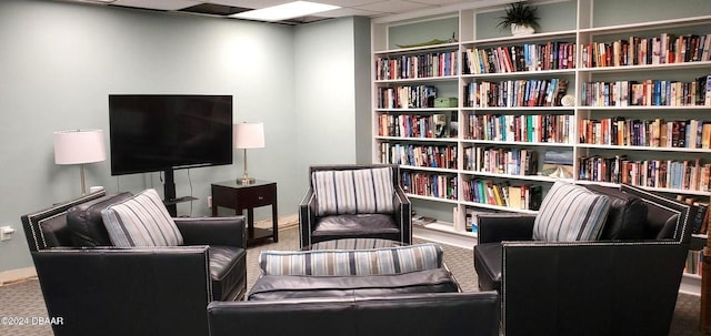 sitting room with carpet and a drop ceiling