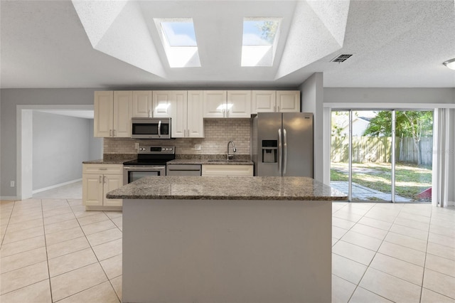 kitchen with tasteful backsplash, visible vents, light tile patterned floors, appliances with stainless steel finishes, and a sink