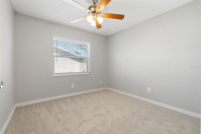 carpeted empty room with a ceiling fan, baseboards, and a textured ceiling