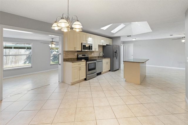 kitchen with light tile patterned flooring, ceiling fan with notable chandelier, and stainless steel appliances