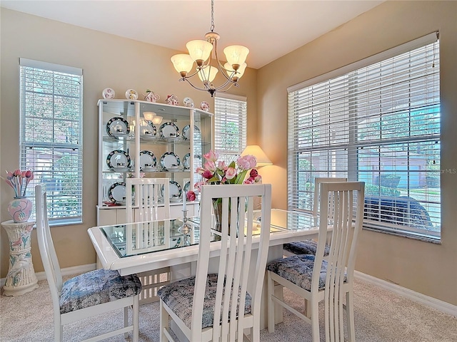 dining area with carpet, baseboards, and a chandelier