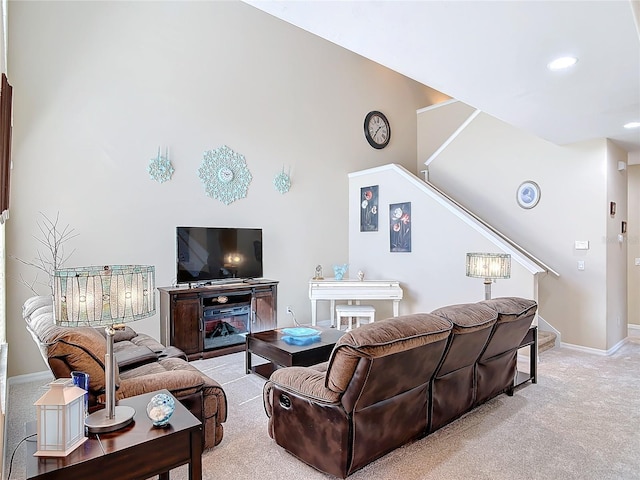 living room with stairway, light colored carpet, and baseboards