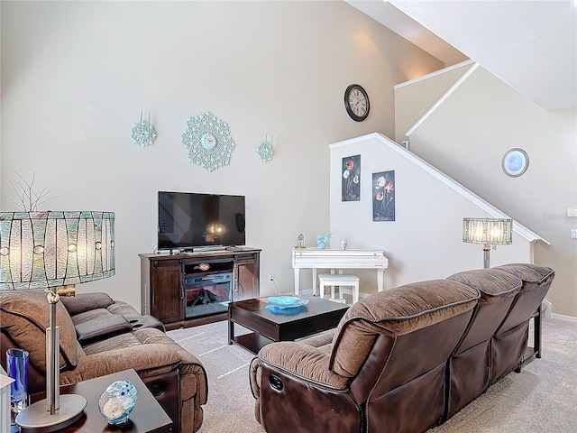 living area featuring stairway, high vaulted ceiling, and carpet floors