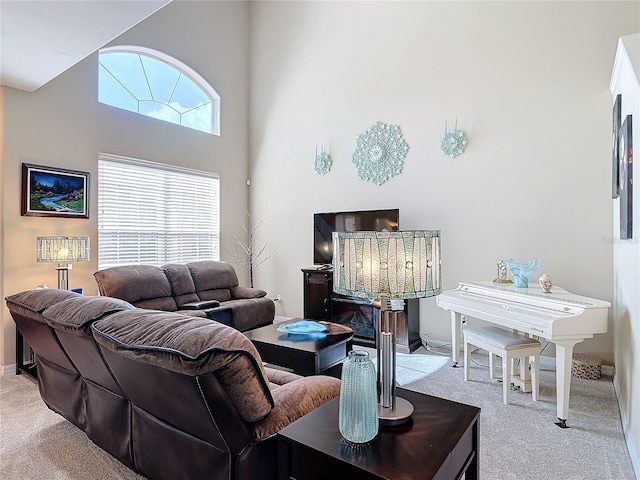 living area with a high ceiling and carpet floors