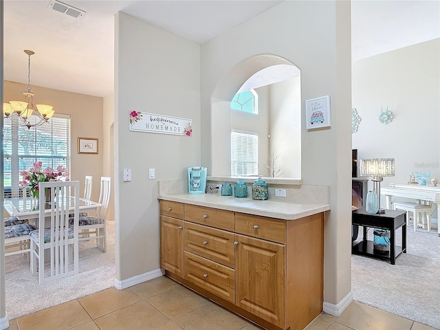 bathroom featuring a chandelier, visible vents, a healthy amount of sunlight, and tile patterned flooring