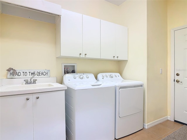 laundry room with light tile patterned floors, cabinet space, independent washer and dryer, and a sink