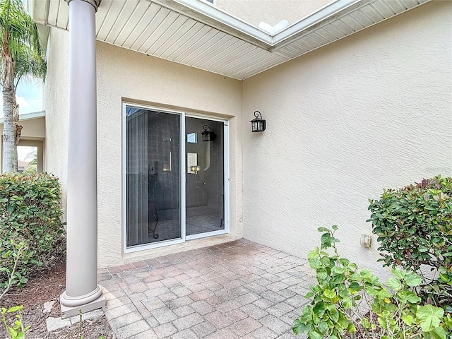 property entrance featuring stucco siding and a patio