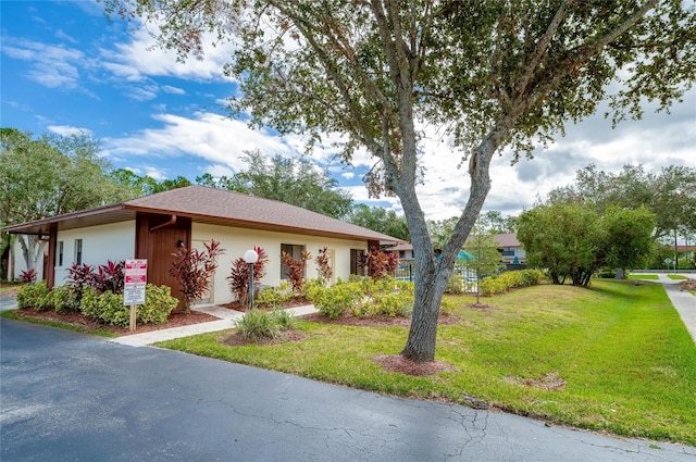 view of front of home with a front yard and stucco siding