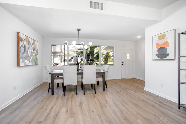 dining space with baseboards, wood finished floors, visible vents, and a chandelier