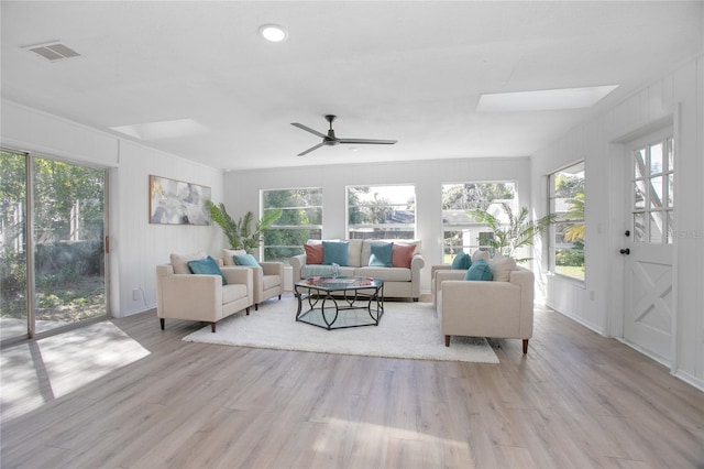 living area featuring visible vents, plenty of natural light, light wood-type flooring, and a ceiling fan